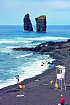 Plaža s tamnim vulkanskim pijeskom.