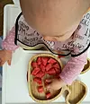 Beba sama istražuje okus voća narezanog tako da može grickati, ali ne i odjednom progutati