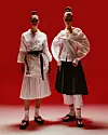 Zinaida nosi karate kimono i pojas, Dechatlon. Plisirana suknja No21, Heraldi. Sunčane naočale Prada, Optika Anda. Tabi čarape, Nike. Natikače, Pull&Bear Magdalena nosi košulju Givenchy, Colognese 1882. Plisirana suknja No21, Heraldi. Hlače za karate, Dechatlon. Sunčane naočale Prada, Optika Anda. Tabi čarape, Nike. Natikače, Bershka