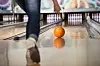 Woman in club for bowling is throwing ball.