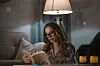Young beautiful woman reading her favourite book in living room at night