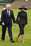 Prva dama Melania Trump odlučila je nositi tamnosivo odijelo Christian Dior Haute Couture u kombinaciji sa znakovitim ljubičastim šeširom