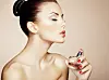 Young beautiful woman with bottle of perfume. Perfect Makeup. Fashion photo