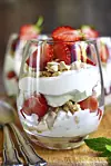 Delisious traditional english dessert eton mess with strawberry on a wooden background.