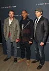 Bradley Cooper (sasvim lijevo) i Kellan Lutz (sasvim desno) na Tommy Hilfiger Men's Fashion Showu 2012. godine. Cooper nosi potpuno raskopčani kaput ispod kojeg viri crveni sako, a Lutz je upario trodjelno odijelo s trapericama i cipelama.