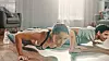 Muscular Athletic Man and Beautiful Fitness Woman in Workout Clothes Doing Push Up Exercises in Their Bright and Spacious Living Room with Minimalistic Interior.