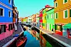 Tipične kuće s fasadama jarkih boja uz kanal na otoku Burano.