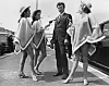 1st June 1967: American actor Clint Eastwood finds himself at the mercy of three gun-toting gals upon his arrival at London Airport to promote his latest film. From left to right, the bare-legged banditos are Sandra Marshall, Anita McGregor and Susan Melody. (Photo by Central Press/Getty Images)