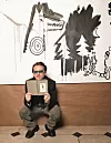 DUBLIN, IRELAND - OCTOBER 3: Singer Bono stands in front of an illustration at the book launch for