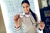 Woman selecting eyeglasses in optical store