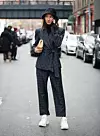 NEW YORK, NY - FEBRUARY 10: A guest poses outside of the Tibi show wearing a plaid suit with white sneakers during New York Fashion Week on February 10, 2019 in New York City. (Photo by Donell Woodson/Getty Images)