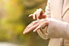 FOTOGRAFIJE: ANTONIOGUILLEM GETTY IMAGES/ISTOCKPHOTO Woman hands in autumn applying moisturizer cream