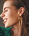 Haljina s plisiranim detaljima i predimenzioniranim rukavima od svile Proenza Schouler; naušnice od pozlate Jil Sander