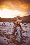 Candid shot of a boho girl walking happily in nature on a peaceful summer evening