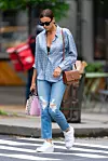 Irina nosi Burberry torbu i majicu, traperice i Nike tenisice.