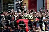 Gledatelji promatraju kako se lijes preminulog norveškog kralja Haralda V. prenosi u kraljevskoj povorci od kapele Kraljevske palače ulicom Karl Johans gate do katedrale