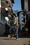 U slikovitoj alpskoj ulici s tradicionalnim drvenim balkonima i pogledom na planinske vrhove u talijanskom odmaralištu Cortina d‘Ampezzo
