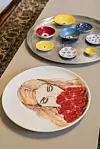 Njezine keramičke posudice i tanjuri imaju motiv ženskog lica te plavog oka koje, prema vjerovanju, štiti od zla