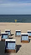 Pješčana plažu na Syltu s prepoznatljivim plavo-bijelim drvenim kabinama za plažu