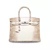 Ferrari Press Agency Birkin 1 Ref 9308 13/06/2018 See Ferrari text Picture credit: Christie’s A ten-year-old matte white Himalaya Birkin broke the European record for a handbag sold at auction when it fetched £162,500 GBP / 7,144 USD / €184.320 Euros at Christie's in London — beating the previous record which stood at £155,000 GBP.Encrusted with 450 diamonds and white gold, the distinctively coloured crocodile skin bag is the most coveted version of the iconic Hermes Birkin range.Fewer than 50 are believed to exist worldwide.The matte white Himalaya was developed by Hermes in 2008, its name inspired by the smoky greys and whites of the snow-capped Himalayan mountains.At 30cm, it is smaller than the original Birkin and made from the hide of farm-raised Nile crocodiles, an African strain of the species that has relatively few bones and is therefore said to have a smoother skin.The bag's white gold diamond-encrusted detailing adds to the value as does the fact so few have been made.The world record-holding Himalaya bag, sold in Hong Kong last year for £292,992 GBP was 'Grade 1,' meaning it was brand new, whereas the one sold in London on June 12 was in Grade 2 condition, which means it has been used.Differences in condition can mean as much as 20 per cent in value.While most second-hand handbags depreciate in value, Hermes Birkins are one of the very few designs to sell for more on the secondary market than their original price.Some generate returns of about 30 per cent a year, and a study by Baghunter — an online marketplace for buying and selling luxury handbags — found Birkin bags have actually outperformed both the American stock market and the price of gold.The French luxury fashion house Hermes designed what became known as the Birkin in 1981.Named after the singer and actress Jane Birkin, it has become one of the most sought-after accessories in the world, but it began as a quest for the perfect holdall.Birkin had met the chief executive of Hermes on a flight from Paris to London, where he offered to design her a holdall and asked if the company could name it after her.She said she was