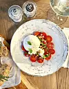 Burrata s cherry rajčicama i prženim pinjolima.