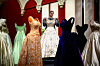 A member of the Royal Collection Trust staff (C) poses amongst the evening gown collection, during a media preview of the exhibition ‘Queen Elizabeth II: Her Life in Style‘ at the King�s Gallery in Buckingham Palace in London on April 9, 2026. The largest exhibition showcasing Queen Elizabeth II�s fashion ever staged is being held from April 10 to October 18, 2026. (Photo by Henry NICHOLLS/AFP)/RESTRICTED TO EDITORIAL USE - NO MARKETING - NO ADVERTISING CAMPAIGNS
