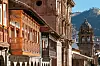 Balconies of colonial buildings with Iglesia La Compania de Jesus (Company of Jesus Church) in background.