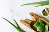 Top view of fresh aloe vera leaves in wooden bowl. spa background concept.