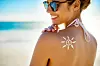 Cropped shot of a young woman posing with suntan lotion on her shoulder
