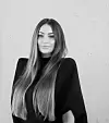 Jelena Bošnjak na crno-bijelom portretu, s dugom raspuštenom kosom i crnim modnim izdanjem.