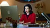 Anne Hathaway u crvenom džemperu sjedi za stolom s Appleovim prijenosnim računalom u filmu Verity.