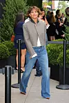 Halle Berry u sivom sakou, bijeloj bluzi i trapericama čeka u redu na događanju Chanel u New Yorku.