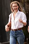 Gigi Hadid u bijeloj košulji, plavim trapericama i smeđoj kožnatoj torbi napušta reviju.