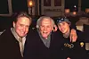 Kirk Douglas, Michael Douglas i Cameron Douglas u tamnoj odjeći poziraju zajedno u zatvorenom prostoru.