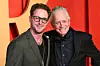 Cameron i Michael Douglas u tamnim odijelima poziraju pred crvenom pozadinom na Vanity Fair Oscar Partyju.