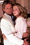 Michael Douglas u bijeloj košulji grli Kathleen Turner u ružičastoj bluzi u filmu „Lov na dragulj s Nila”.