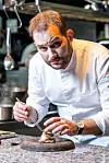 Chef Hrvoje Kroflin u bijeloj kuharskoj odori pincetom dovršava jelo s tartufima u kuhinji restorana ManO2.