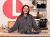 Julianne Moore u sivoj košulji nasmijana stoji za kuhinjskim pultom u emisiji Lorraine.