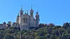 Bazilika Notre-Dame de Fourvière na zelenom brežuljku iznad Lyona pod vedrim plavim nebom
