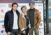 Mads Mikkelsen u smeđoj jakni sa suprugom i sinom ispred sponzorskog zida u Kopenhagenu.