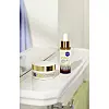 NIVEA Q10 maslac u teglici i serum s kapaljkom na bijelom umivaoniku.