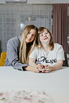 Ana Maria i Kristina Vajda sjede za stolom; jedna nosi sivi sako, a druga bijelu majicu s natpisom.