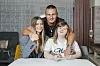 Ivan, Ana Maria i Kristina Vajda poziraju u dnevnom boravku; Ana Maria nosi sivu vestu, a Kristina bijelu majicu.