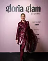 Žena u bordo metalik haljini i tamnom krznenom ogrtaču pozira pred zidom Gloria Glam.
