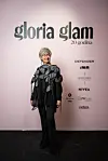 Žena sa srebrnom kratkom kosom u crnom modnom izdanju pozira na događanju Gloria Glam.