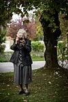 Slavka Pavić u tamnom kaputu fotografira u vrtu doma Senior Garden u Zagrebu.