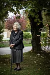 Slavka Pavić u crnom sakou i dugoj suknji stoji uz štap u jesenskom vrtu doma Senior Garden.