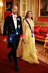 Princ William u crnom svečanom odijelu i Catherine u žutoj haljini hodaju kroz raskošno uređeni dvorac Windsor.