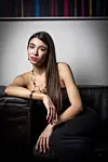 Ana Pogorelić u crnom topu i hlačama sjedi na kožnom kauču u zagrebačkom stanu.