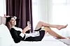Instead of work. Positive female hotel maid resting on the bed while not wanting to work